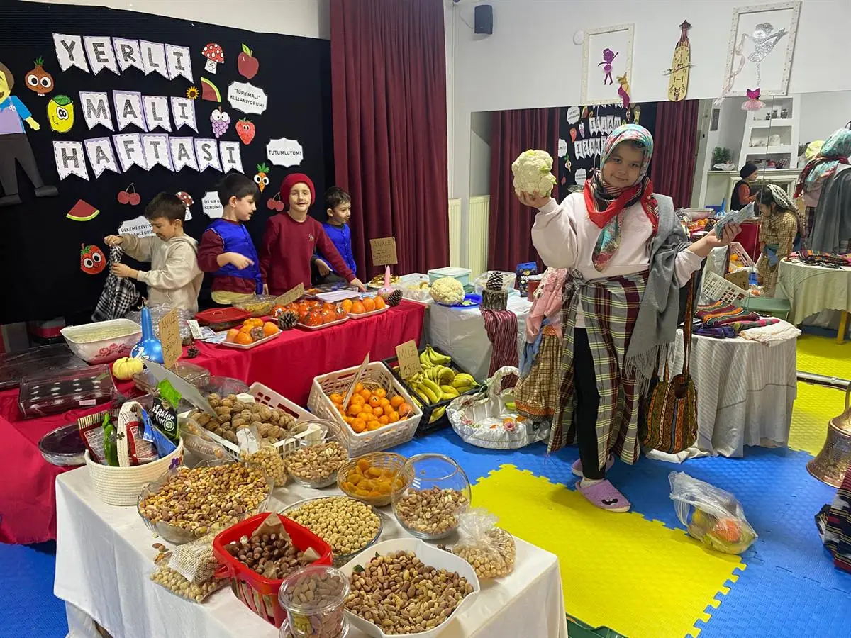 Yerli Malı Haftası panosunun önünde kurulan kuruyemiş ve meyve tezgâhı
